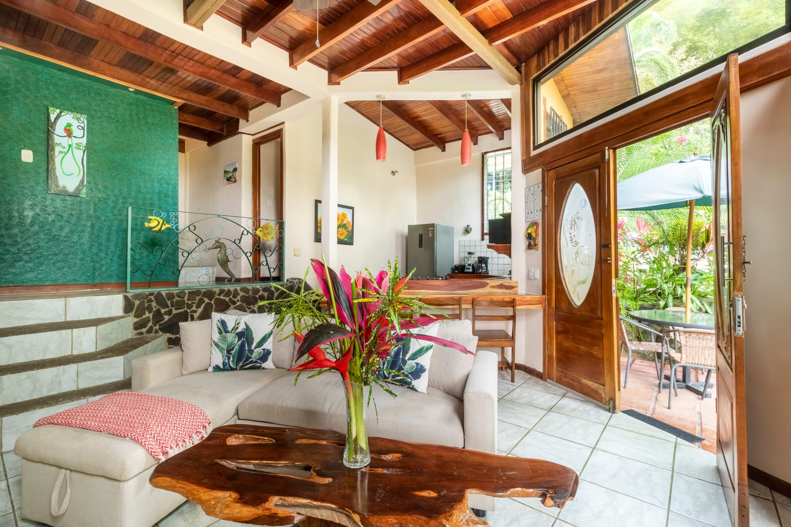 A living area at Las Cascadas with a wooden ceiling, a sofa and a dining table