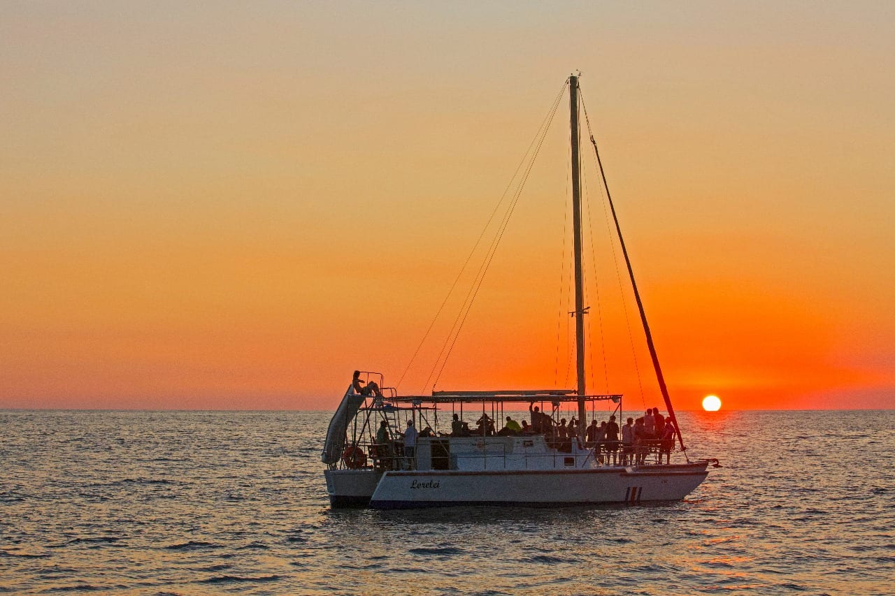 A tour boat on the water as the sun drops