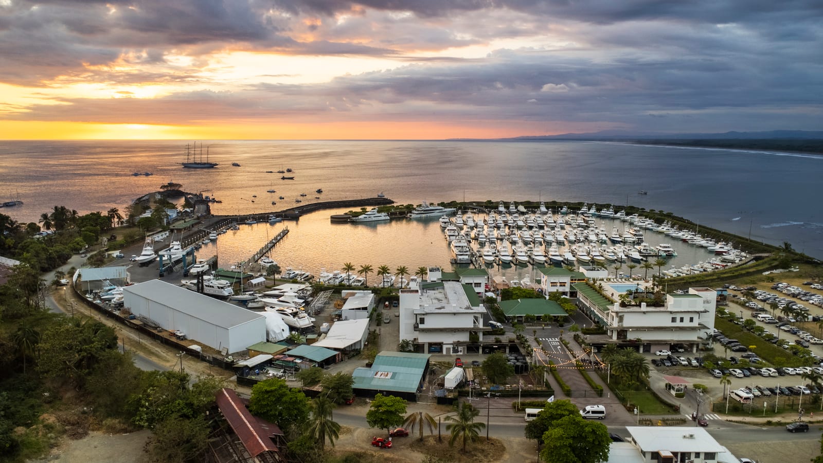 Marina Pez Vela from the air at sunset, boats moored along the pontoons