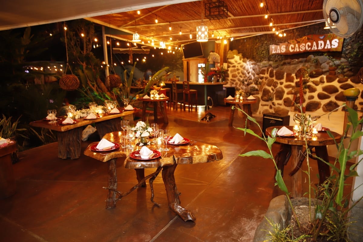 The terrace at night set for a wedding dinner under strings of lights